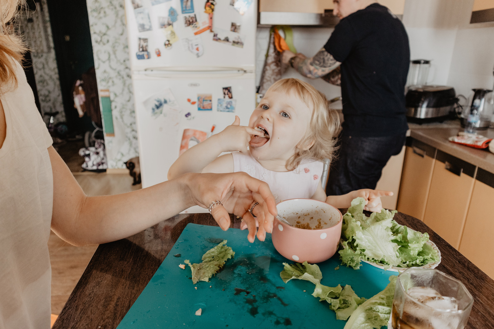 Criança experimentando alimentos em uma mesa de uma cozinha