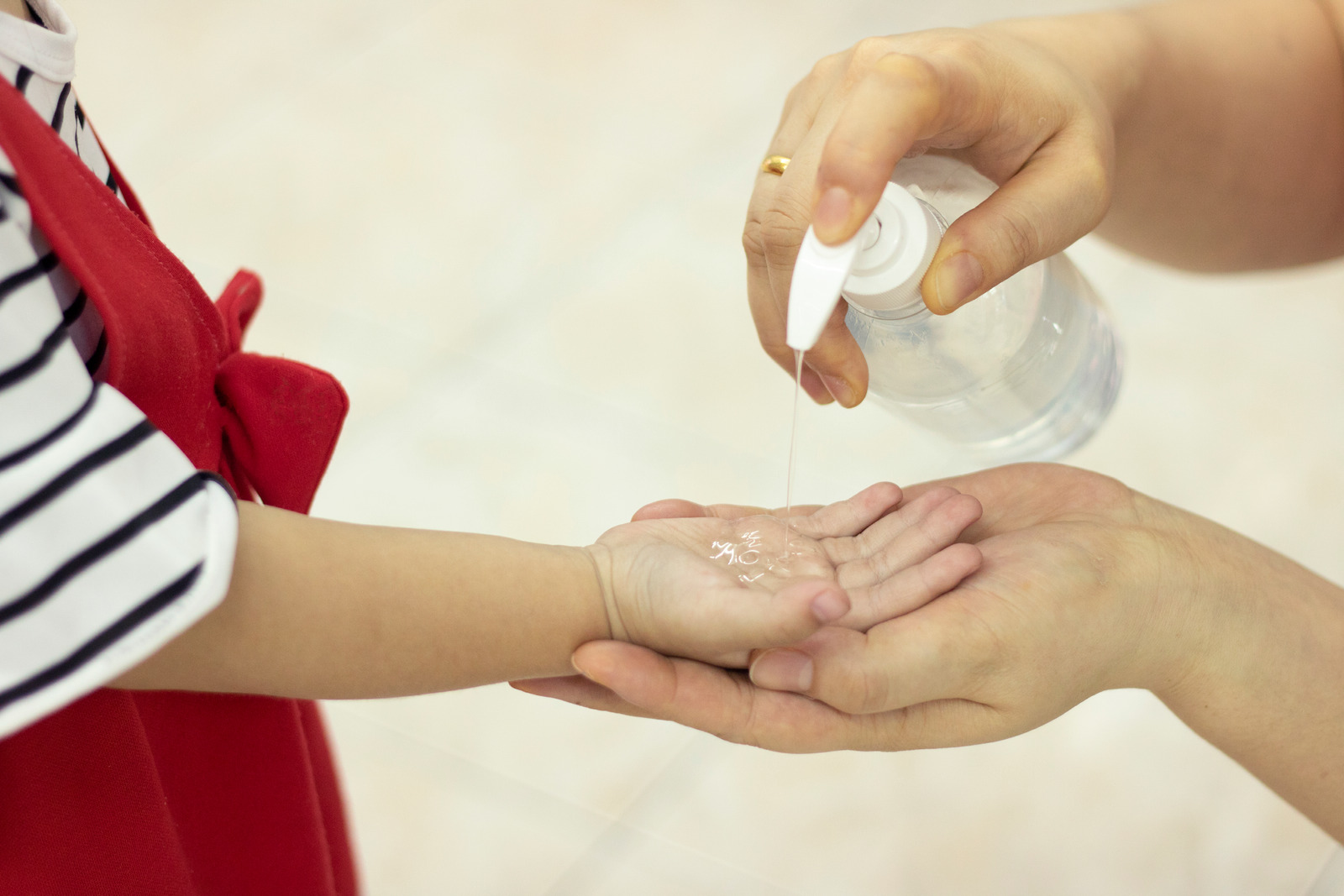 Criança limpando a mão com alcoolgel. 