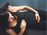 mulher grávida com a mão na barriga