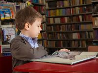 criança estudando em biblioteca